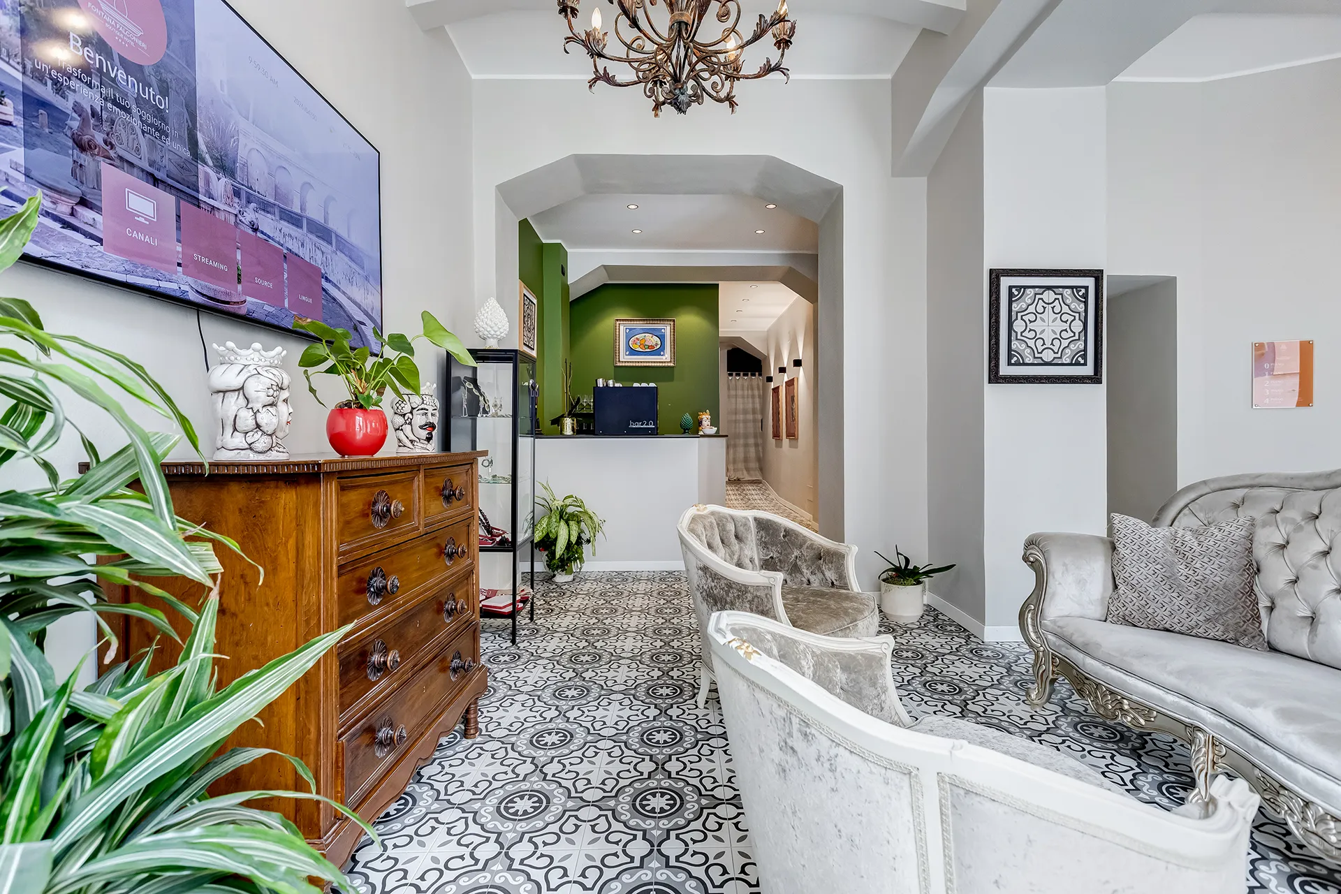 Area lounge elegante del boutique hotel a Messina con divano in stile classico e reception